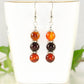 Natural Carnelian Beaded Bar Earrings displayed on a tea cup.