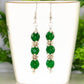 Natural Emerald Beaded Bar Earrings displayed on a tea cup.