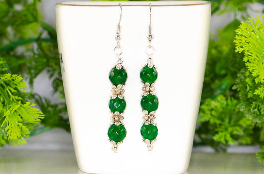 Natural Emerald Beaded Bar Earrings displayed on a tea cup.