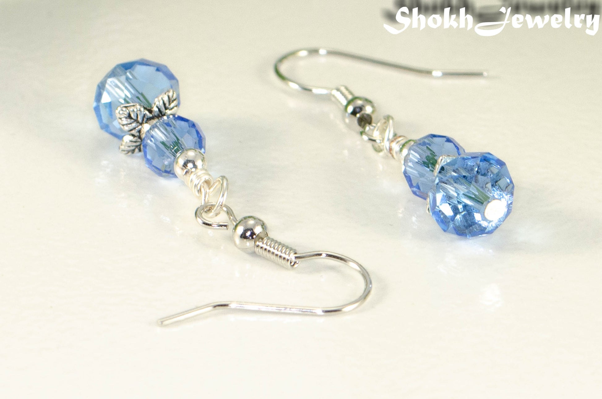 Close up of Small Light Blue Glass Bead Dangle Earrings.