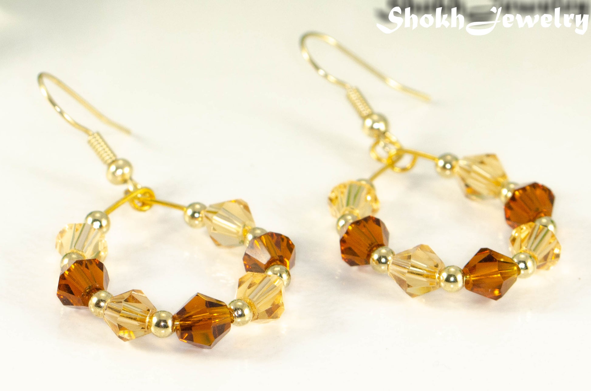 Close up of Amber and Brown Glass Crystal Hoop Earrings.