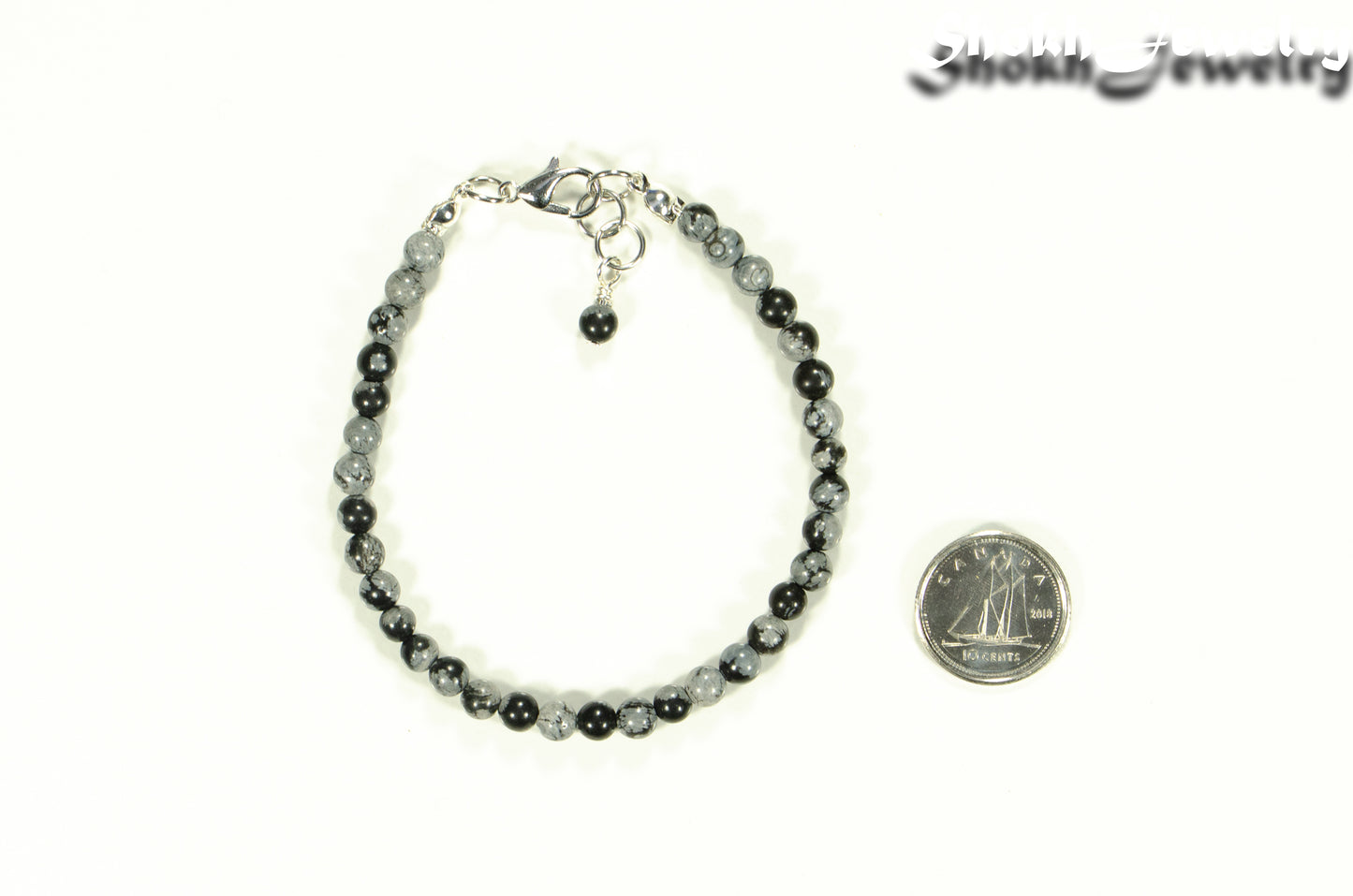 4mm Snowflake Obsidian Stone Bracelet with Clasp beside a dime.
