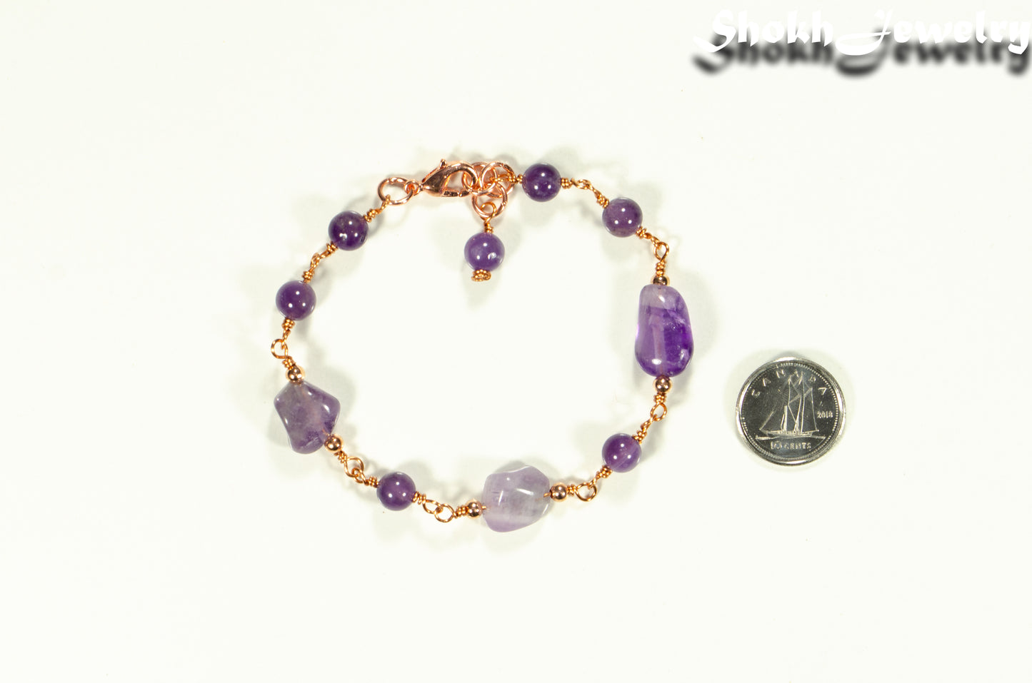 Chunky Amethyst Nugget and Beads Link Bracelet beside a dime.