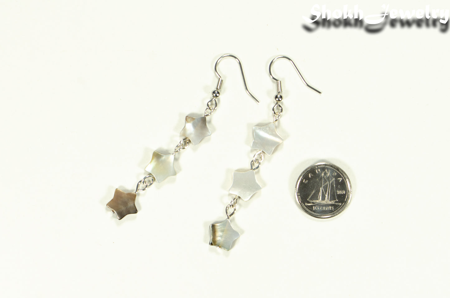 Long Natural Seashell Star Earrings beside a dime.