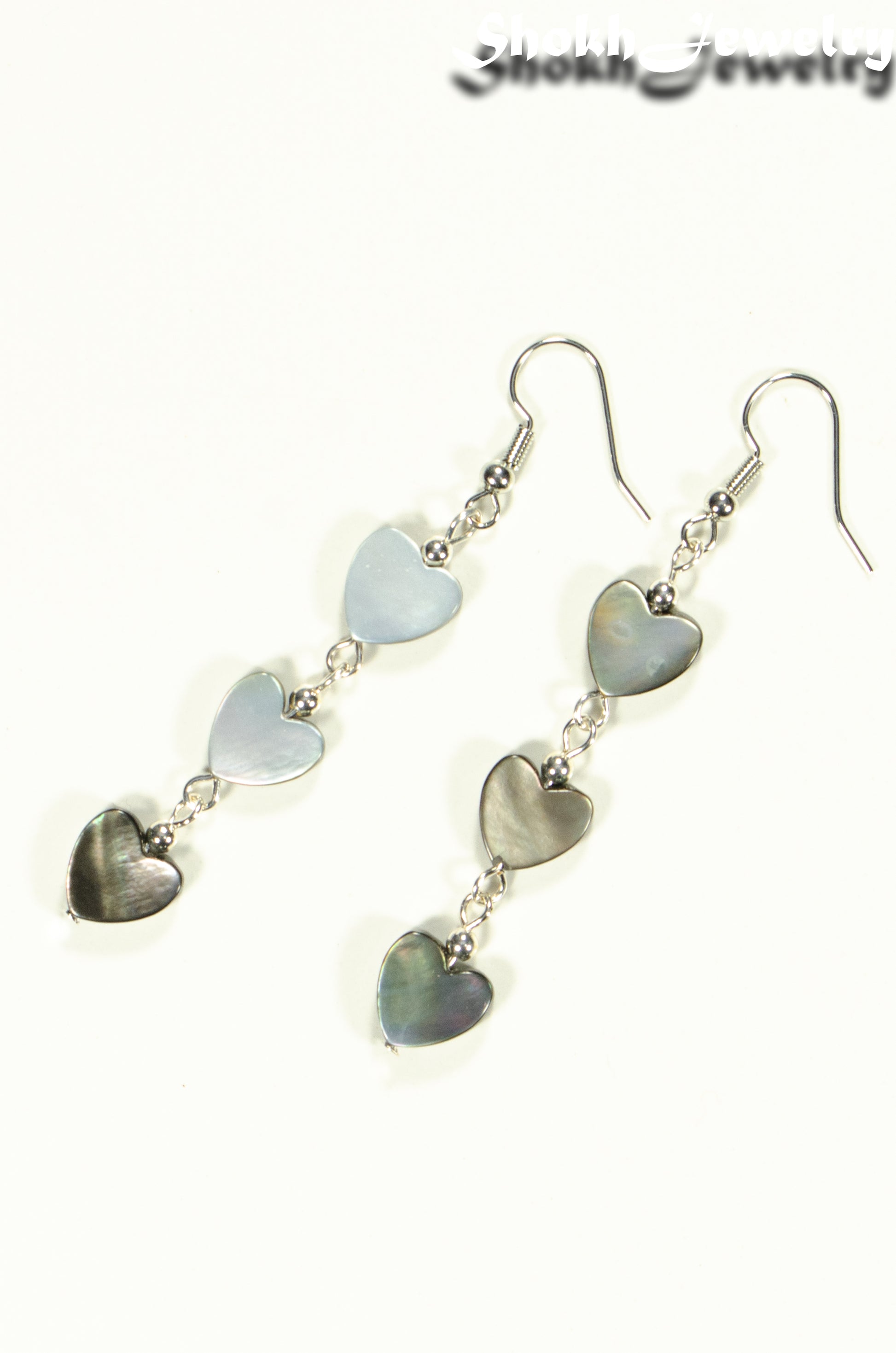 Top view of Long Grey Seashell Hearts Earrings.