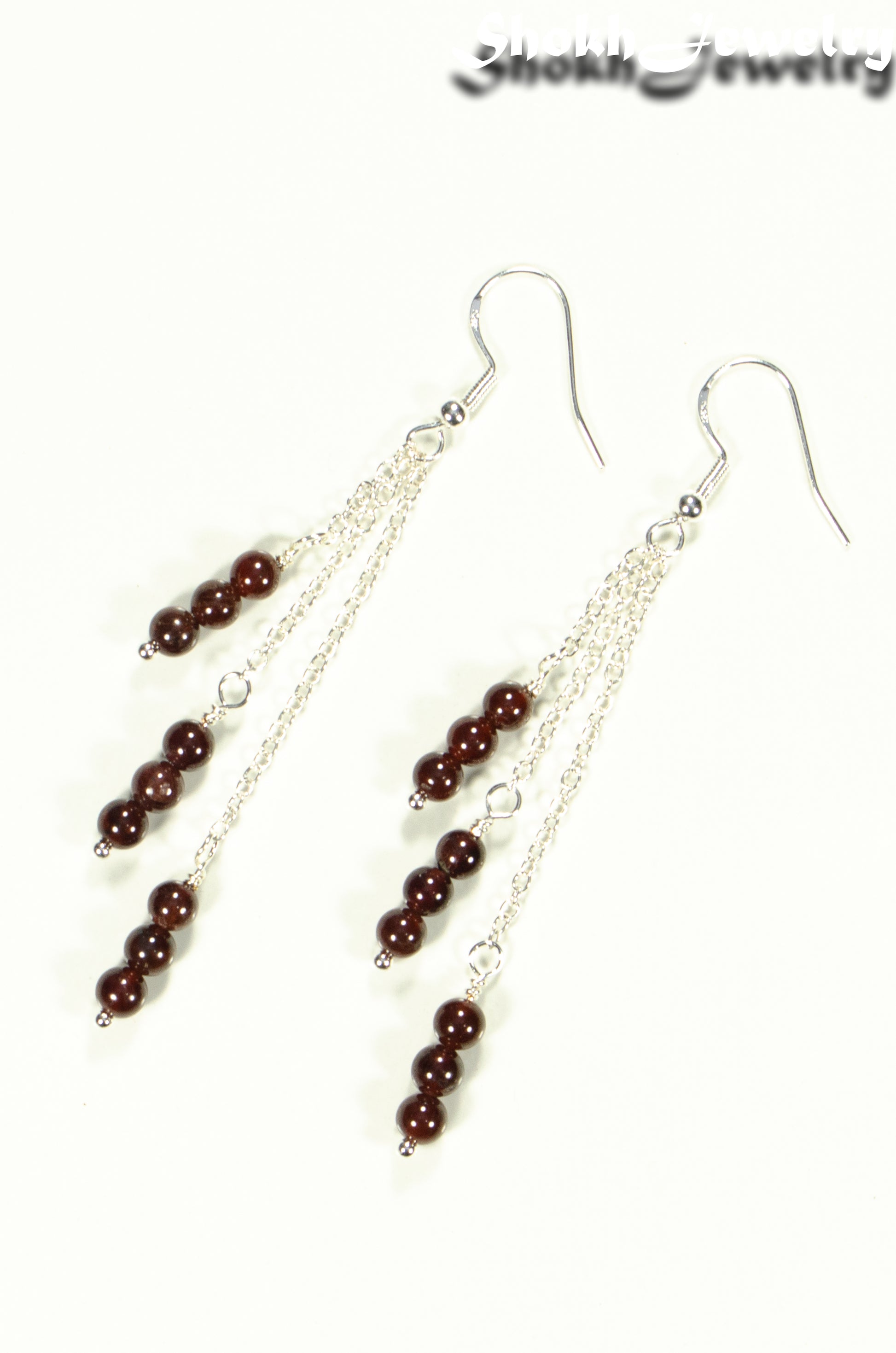 Top view of Silver Plated Chain and Garnet Crystal Earrings.