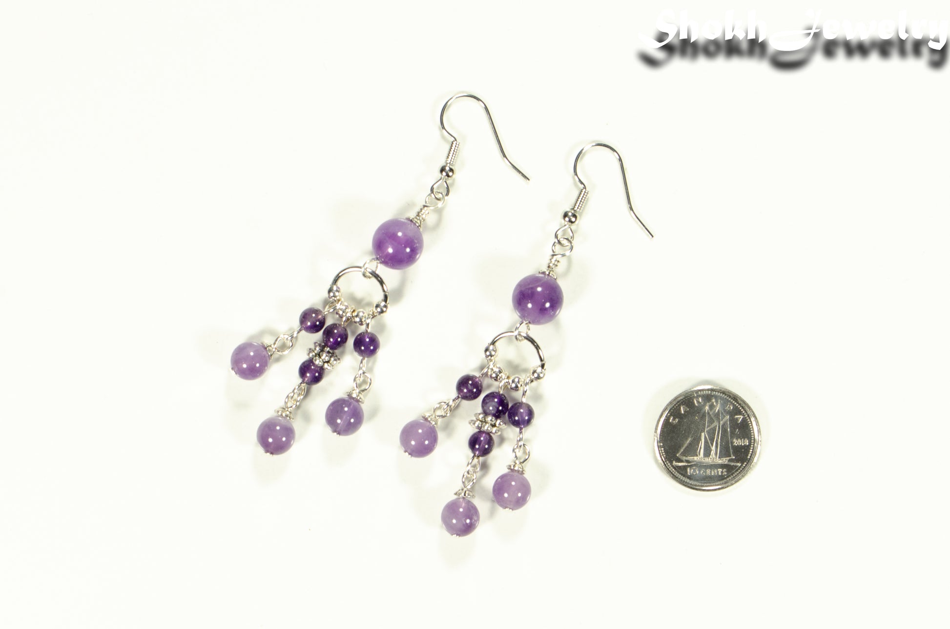 Statement Amethyst Crystal Chandelier Earrings beside a dime.