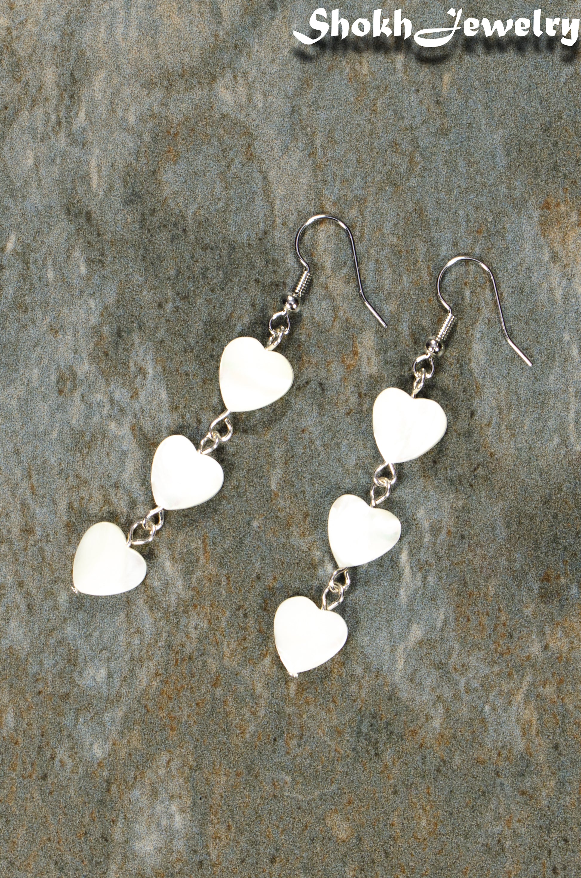 Top view of Long White Seashell Hearts Earrings.