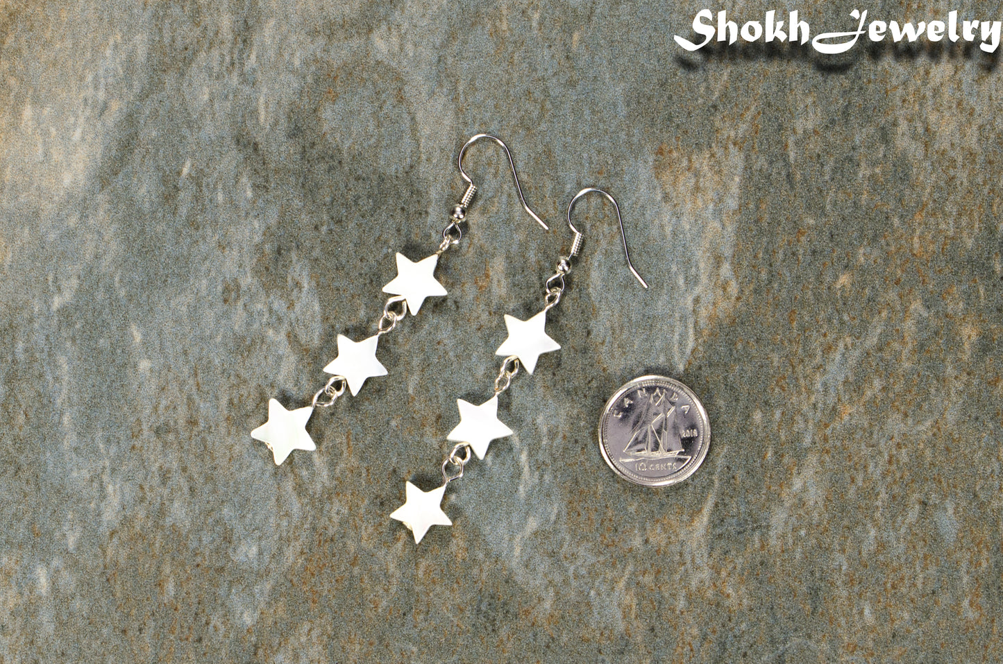Long Natural White Seashell Star Earrings beside a dime.