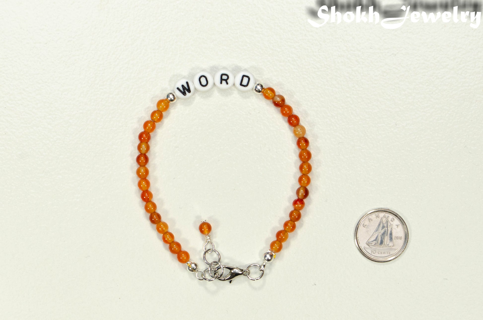 Personalized Carnelian Crystal Bracelet with Clasp beside a dime.