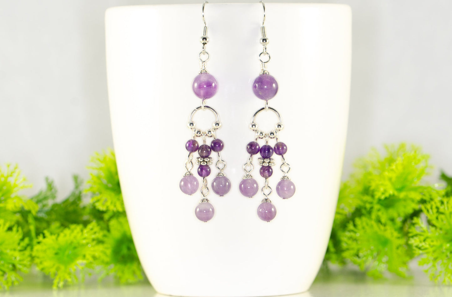 Statement Amethyst Crystal Chandelier Earrings displayed on a coffee mug.