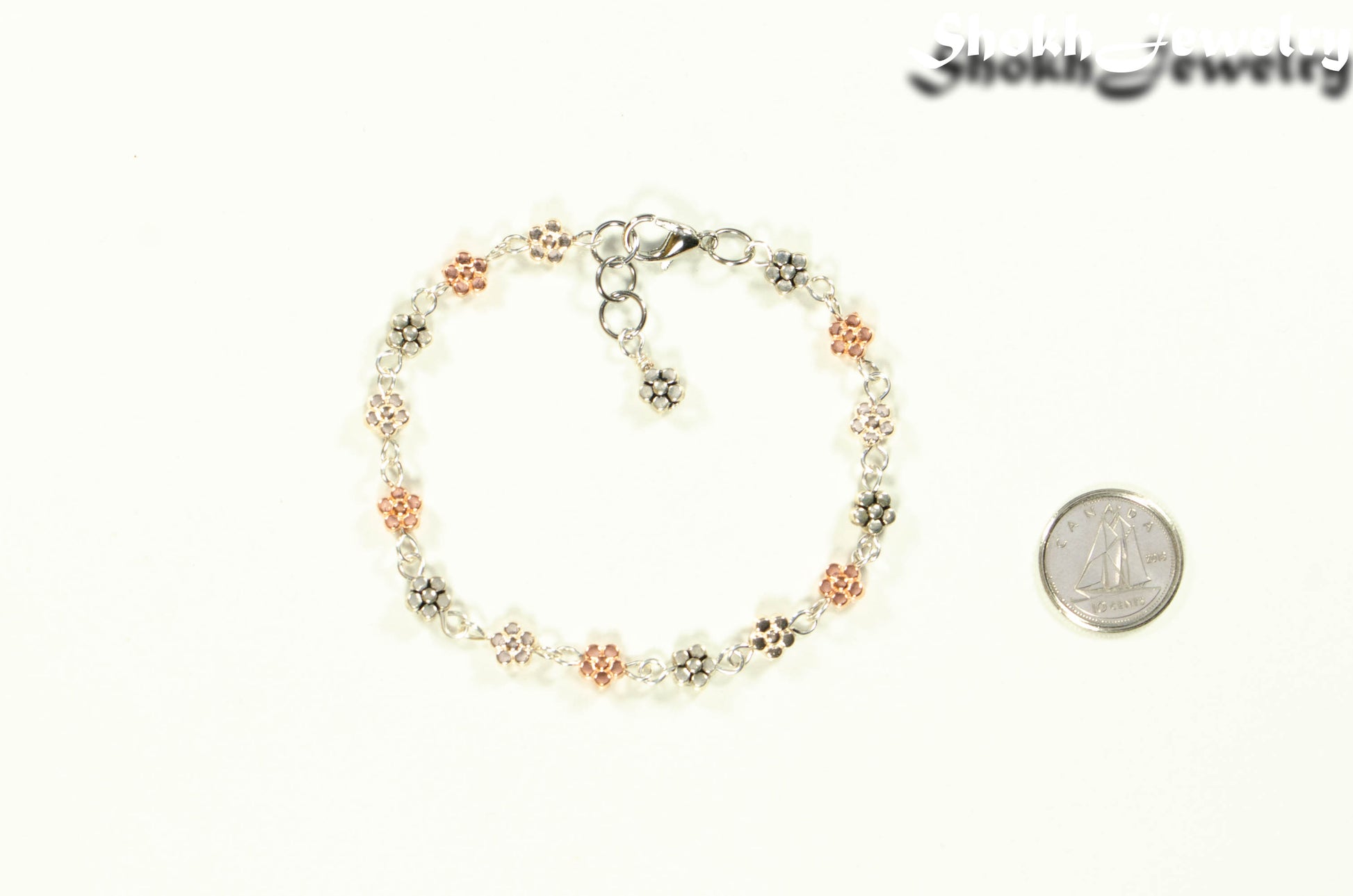 Multi Metal Flower Link Bracelet beside a dime.