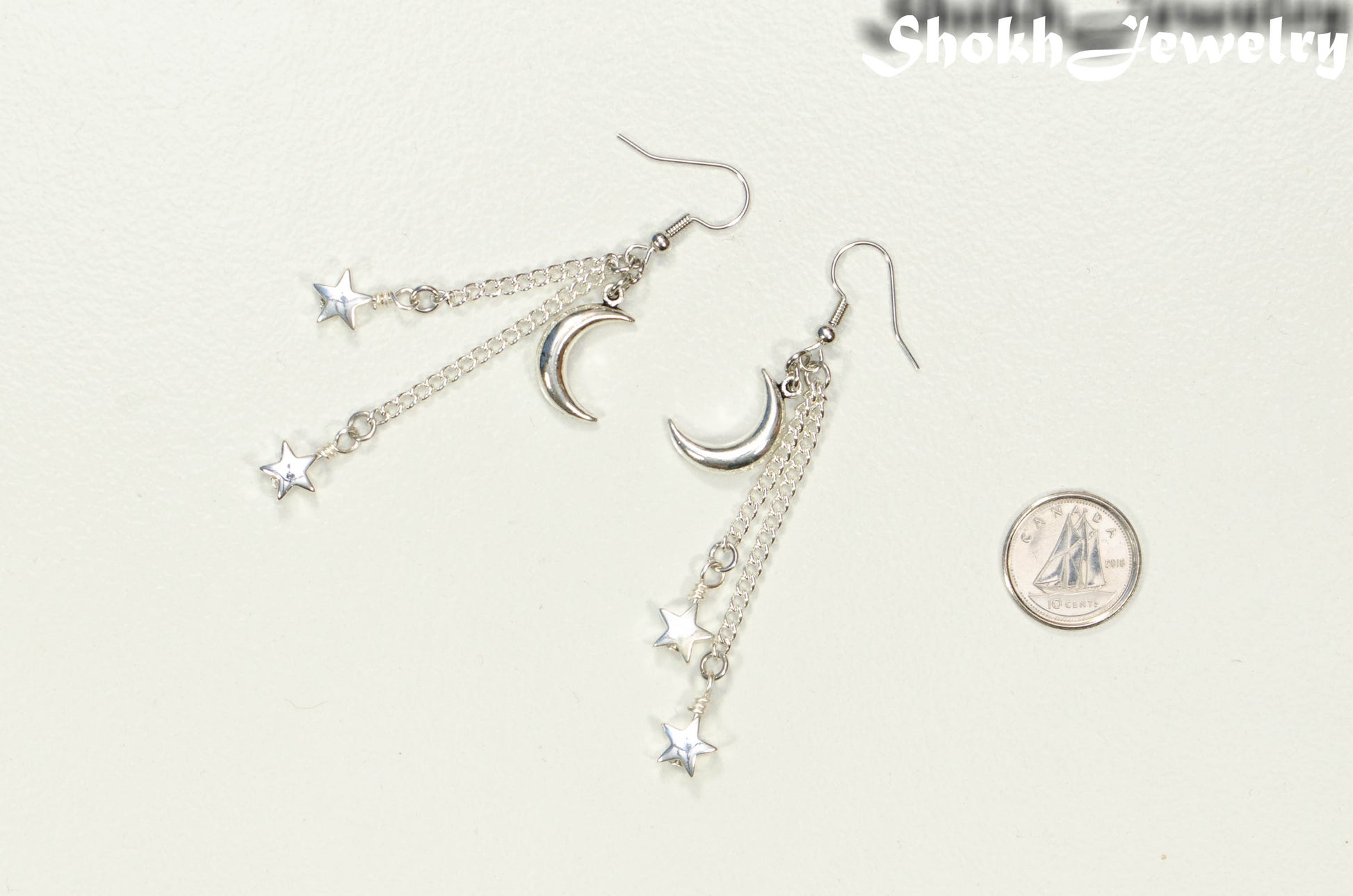 Long Crescent Moon and Hematite Star Earrings beside a dime.