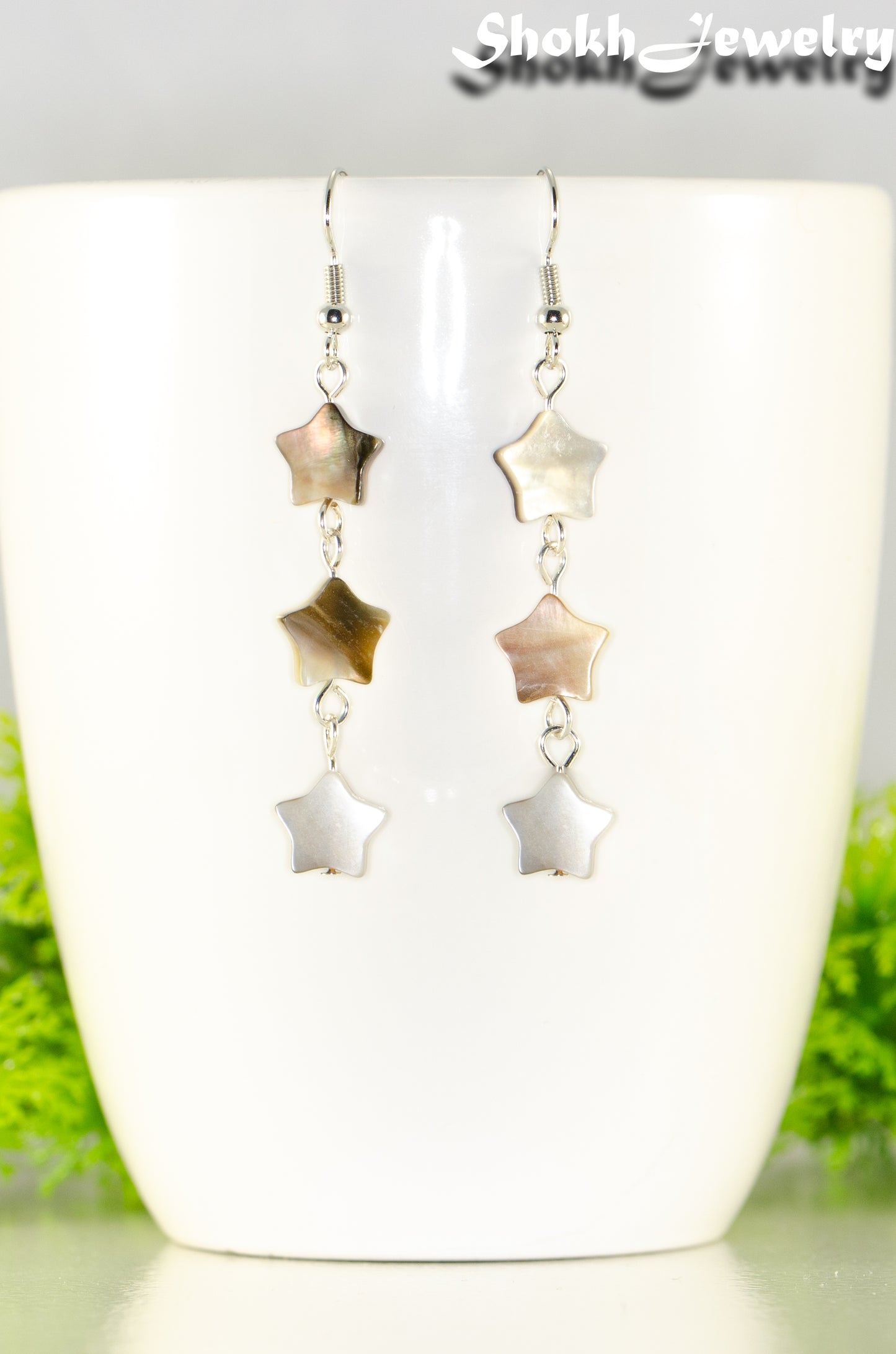 Close up of Long Natural Seashell Star Earrings.