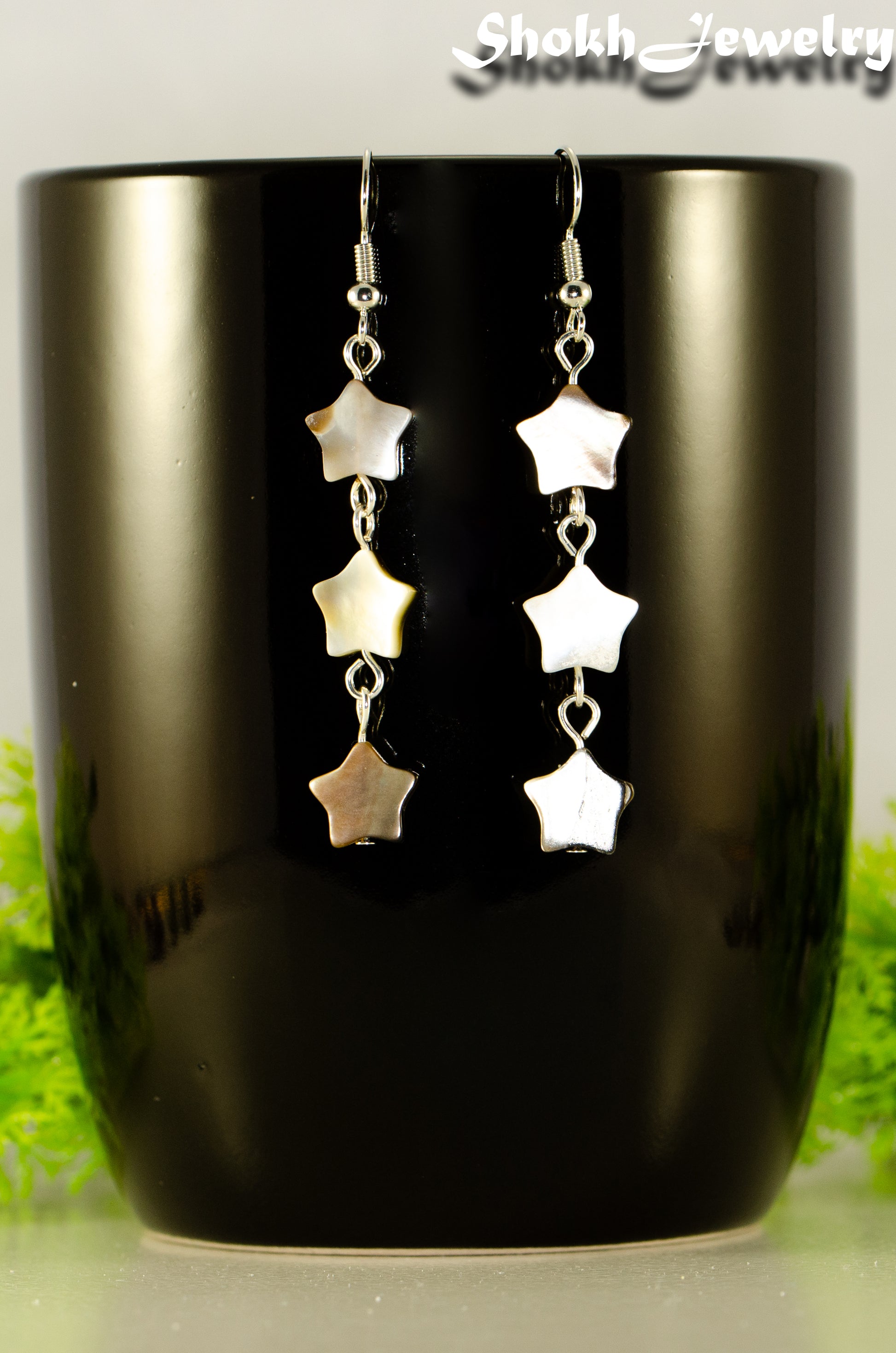 Close up of Long Natural Seashell Star Earrings.