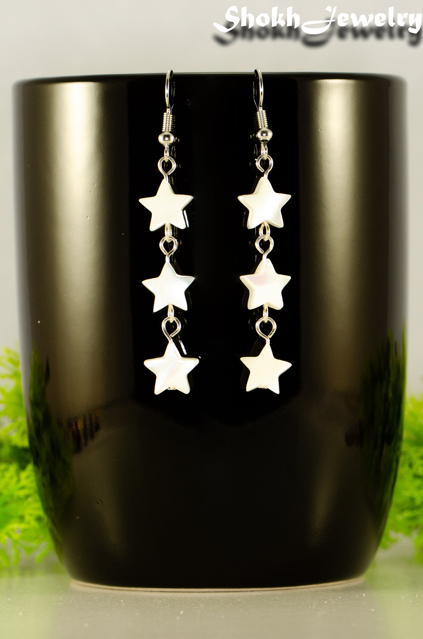 Close up of Long Natural White Seashell Star Earrings.