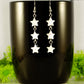Long Natural White Seashell Star Earrings displayed on a coffee mug.