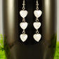 Close up of Long White Seashell Hearts Earrings