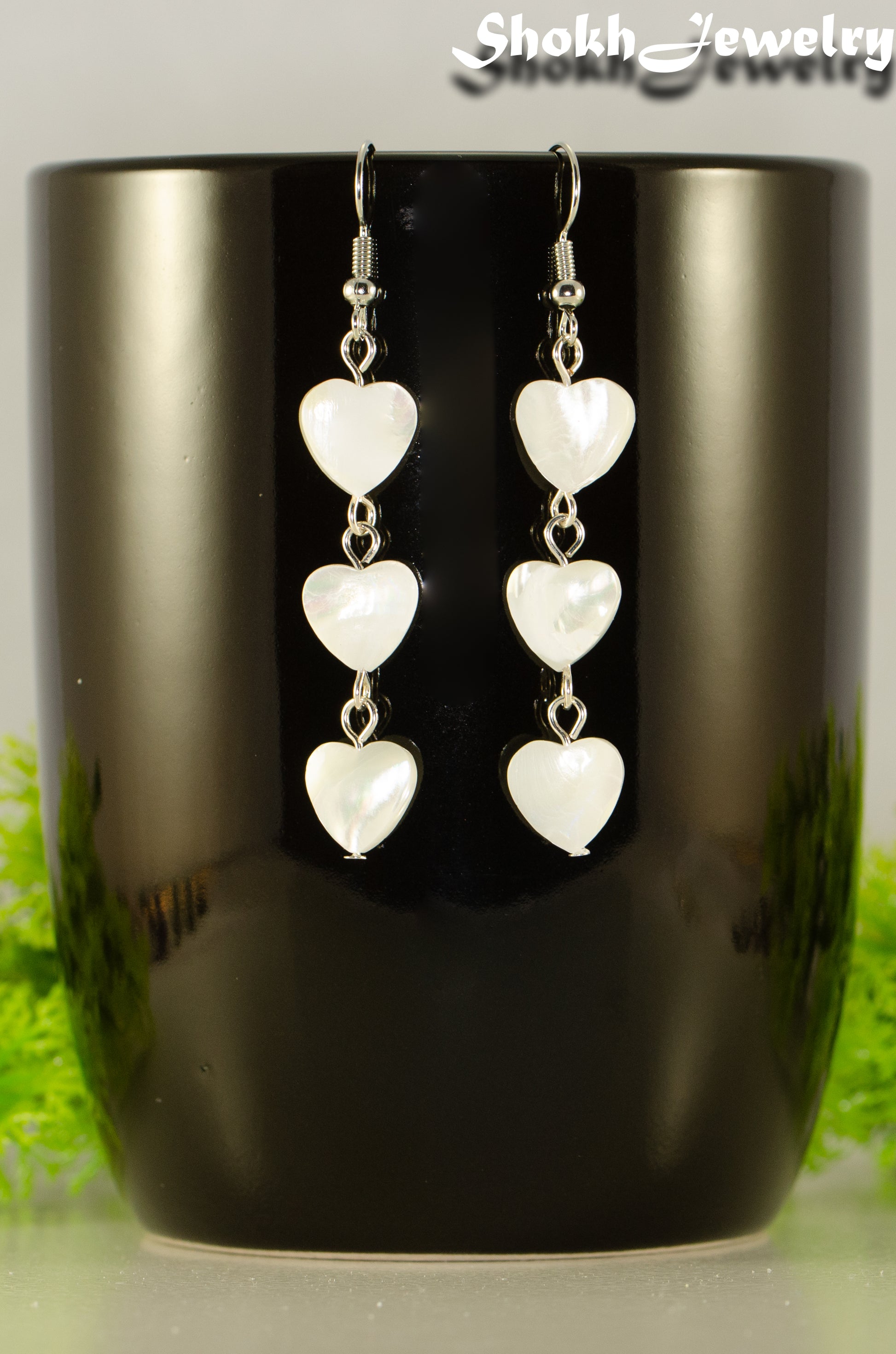 Close up of Long White Seashell Hearts Earrings