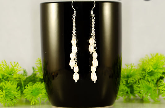 Long Silver Plated Chain and Freshwater Pearl Earrings displayed on a coffee mug.