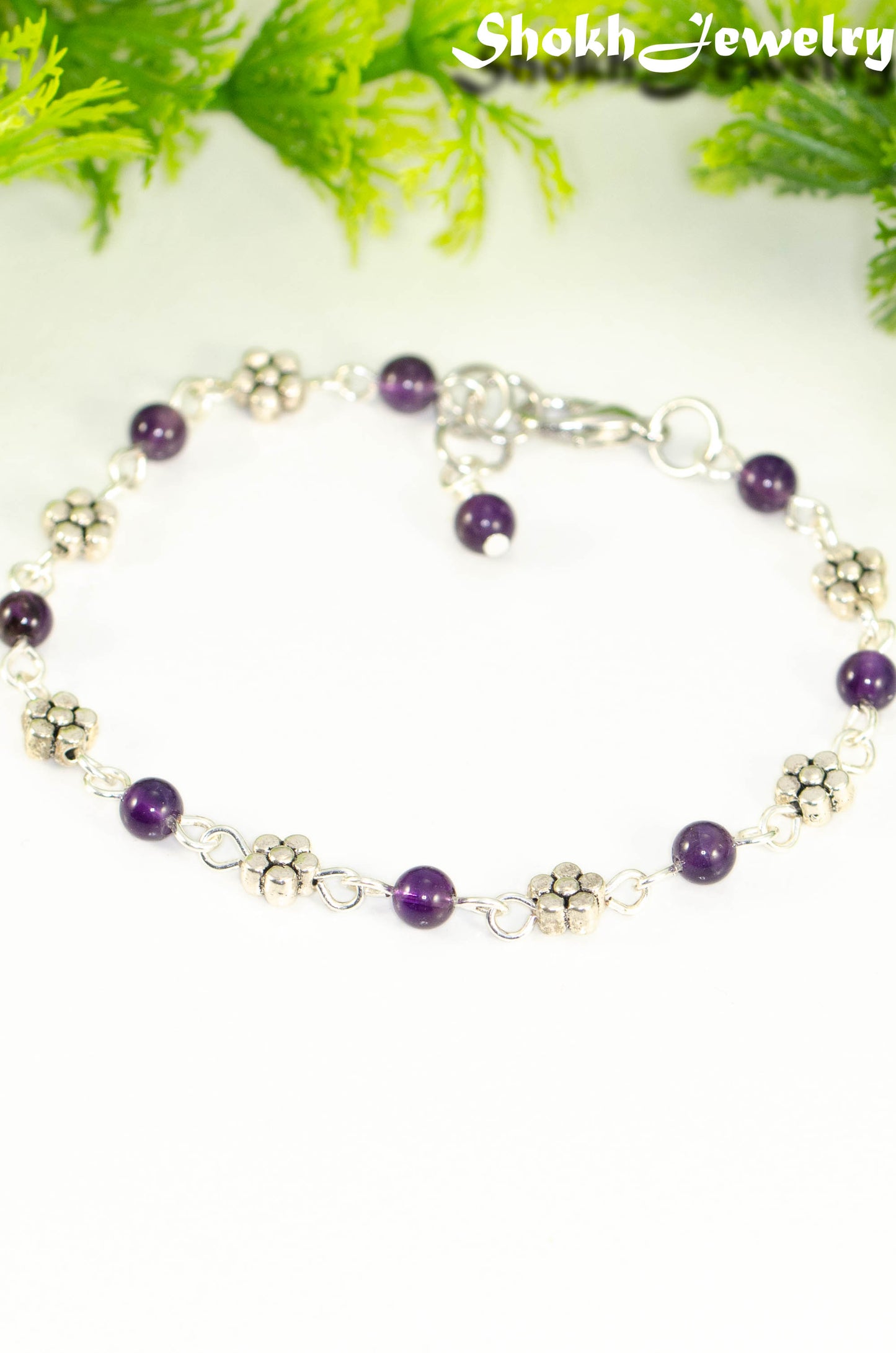 Close up of Tibetan Silver Flower and Amethyst Link Bracelet.