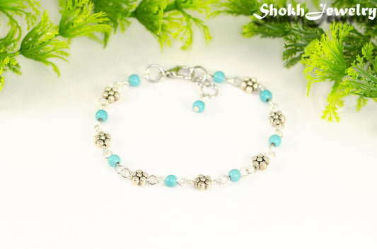 Tibetan Silver Flower and Turquoise Howlite Link Bracelet with lobster claw clasp closure.