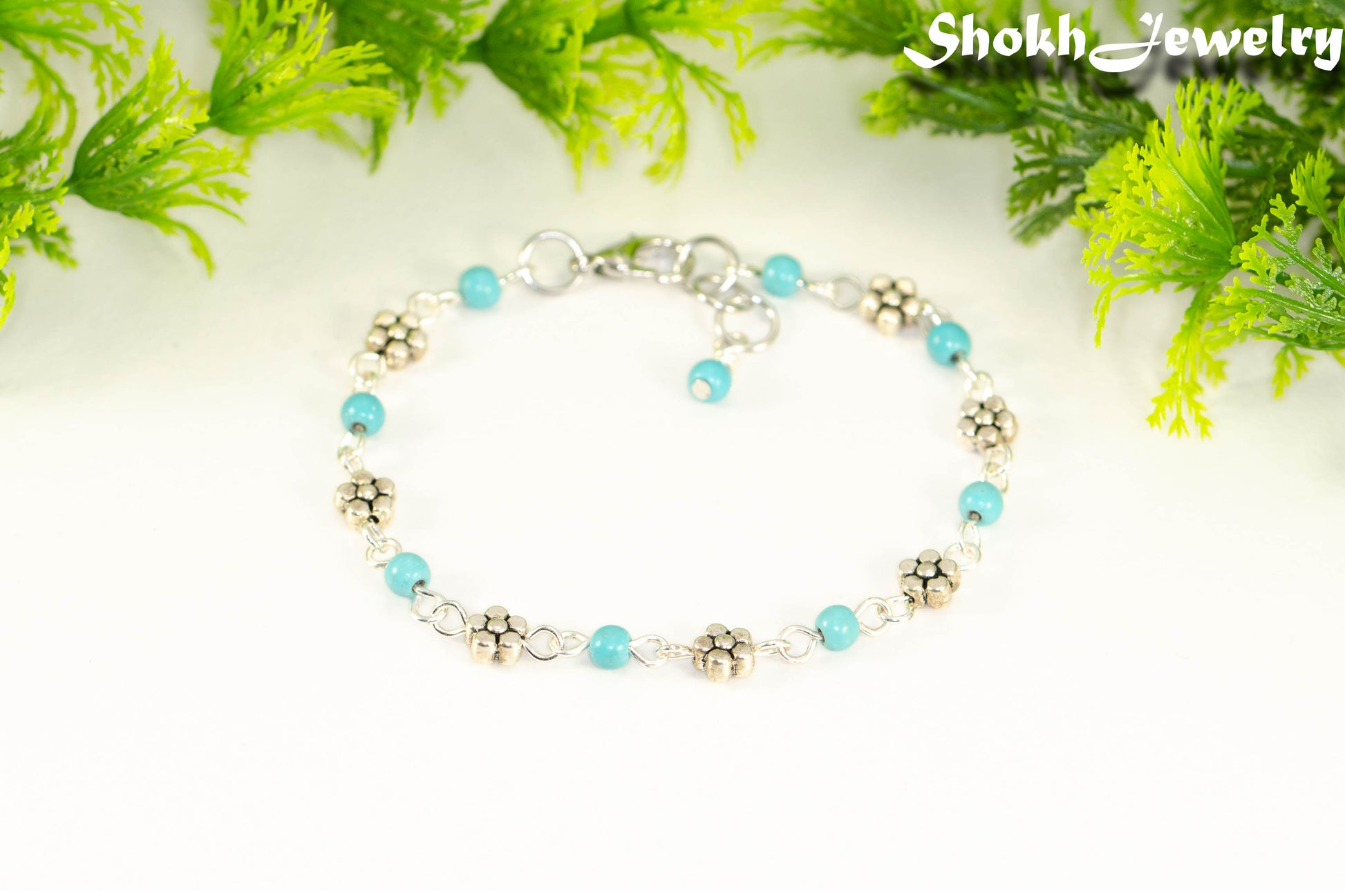 Tibetan Silver Flower and Turquoise Howlite Link Bracelet with lobster claw clasp closure.