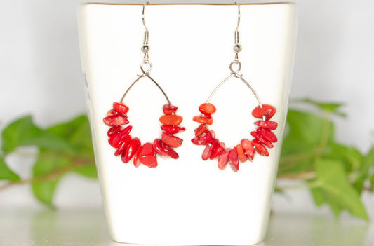 Natural Red Coral Crystal Chip Earrings displayed on a tea cup.