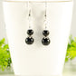 Small Black Tourmaline Earrings displayed on a tea cup.