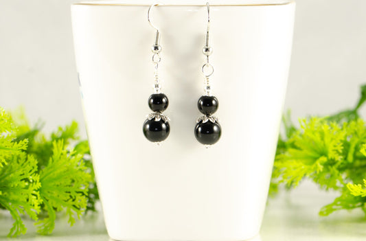 Small Black Tourmaline Earrings displayed on a tea cup.