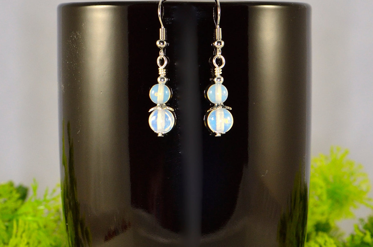 Small Opalite Crystal Earrings displayed on a coffee mug.