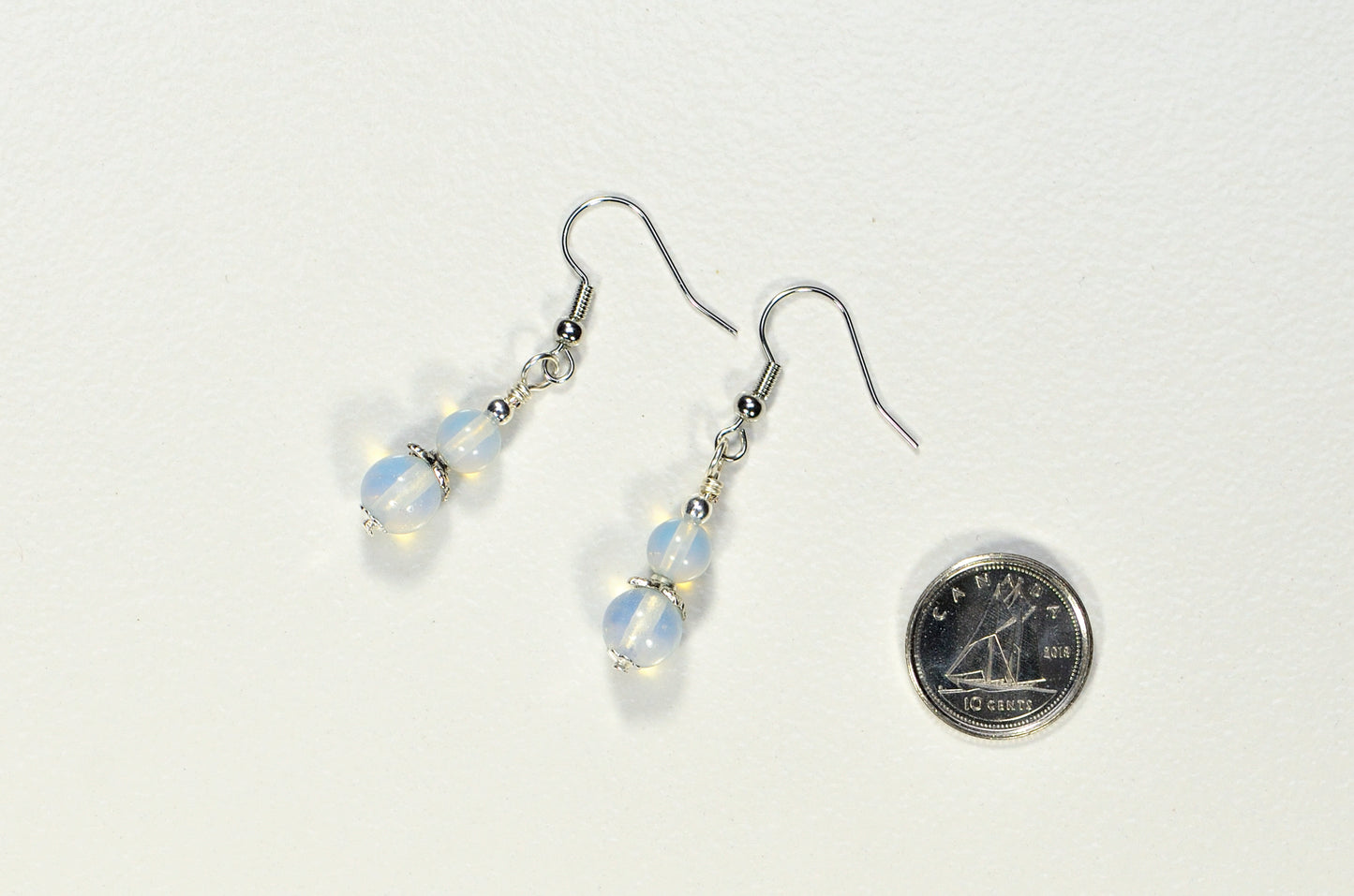 Small Opalite Crystal Earrings beside a dime.