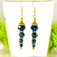 Sparkly Blue Glass Crystal Bead Earrings displayed on a tea cup.