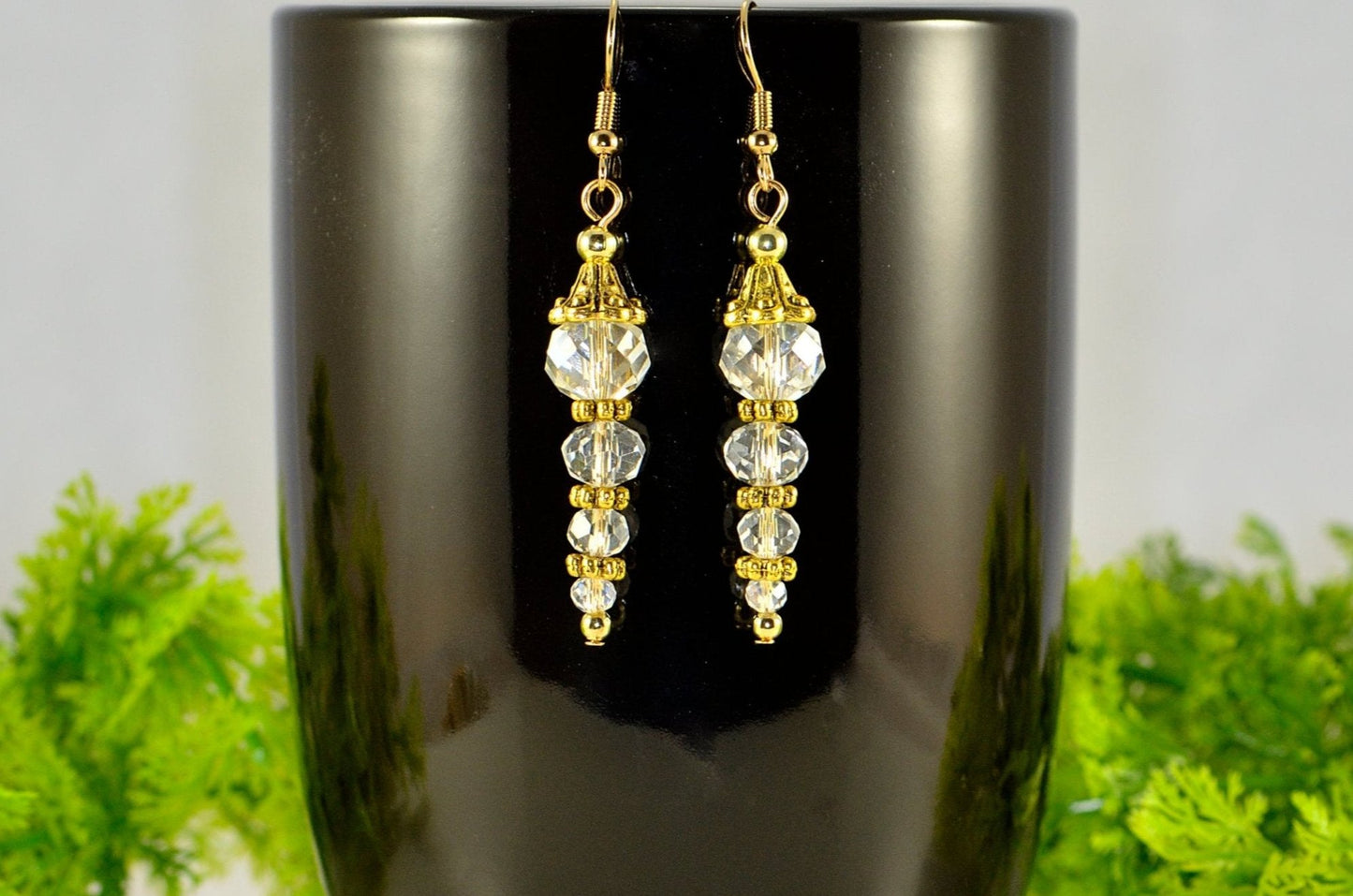 Sparkly Crystal Clear Glass Bead Earrings displayed on a coffee mug.