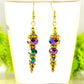 Sparkly Gold Glass Crystal Bead Earrings displayed on a tea cup.