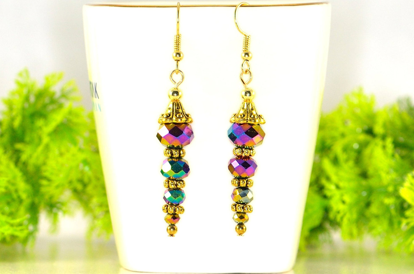 Sparkly Gold Glass Crystal Bead Earrings displayed on a tea cup.