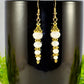 Sparkly White Glass Crystal Bead Earrings displayed on a coffee mug.