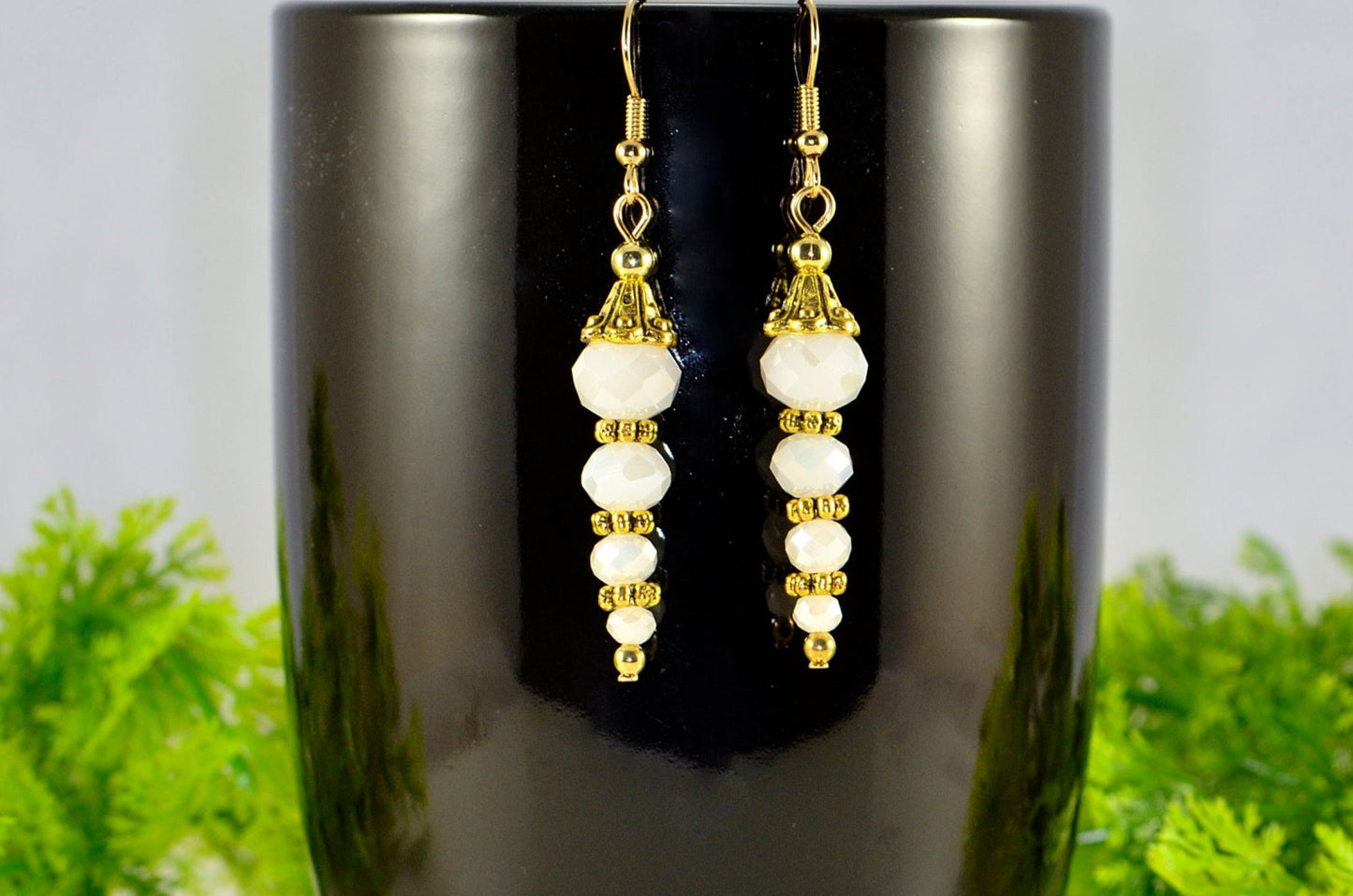 Sparkly White Glass Crystal Bead Earrings displayed on a coffee mug.