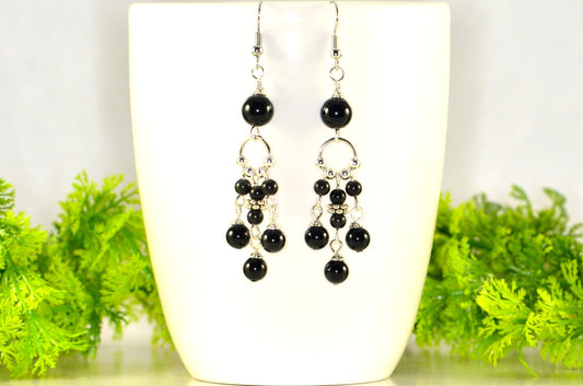 Statement Black Obsidian Chandelier Earrings displayed on a coffee mug.