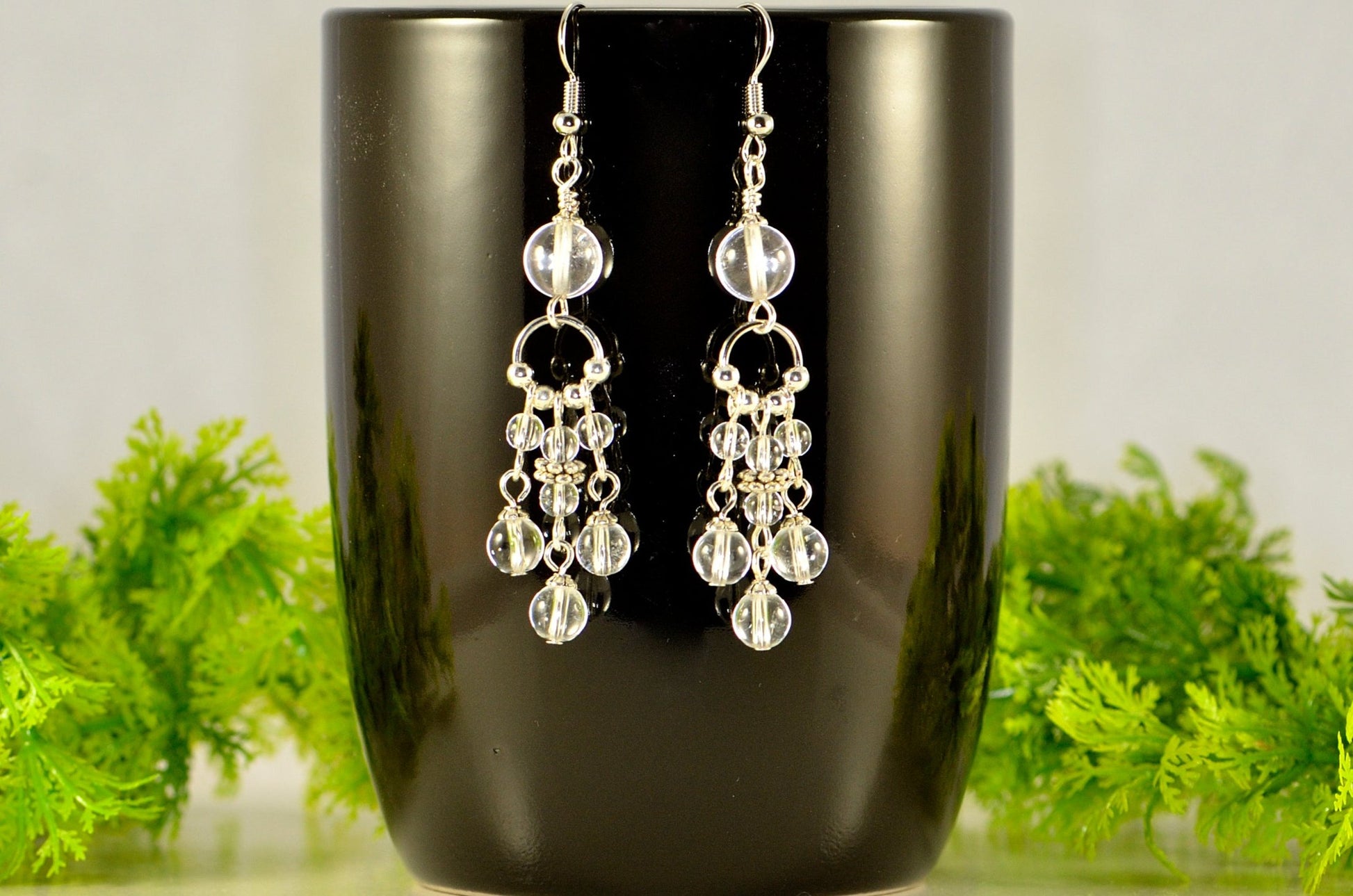 Statement Clear Quartz Chandelier Earrings displayed on a coffee mug.