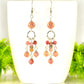 Statement Pink Rhodonite Chandelier Earrings displayed on a coffee mug.