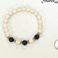 White Howlite and Black Lava Stone Bracelet beside a dime.