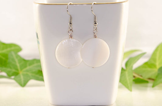 20mm White Seashell Earrings displayed on a tea cup.
