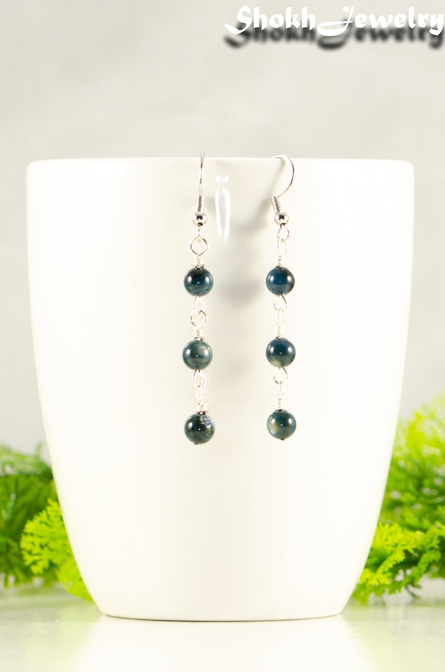 Dark Blue Natural Seashell Earrings displayed on a coffee mug.