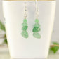 Simple Green Aventurine Crystal Chip Earrings displayed on a tea cup.