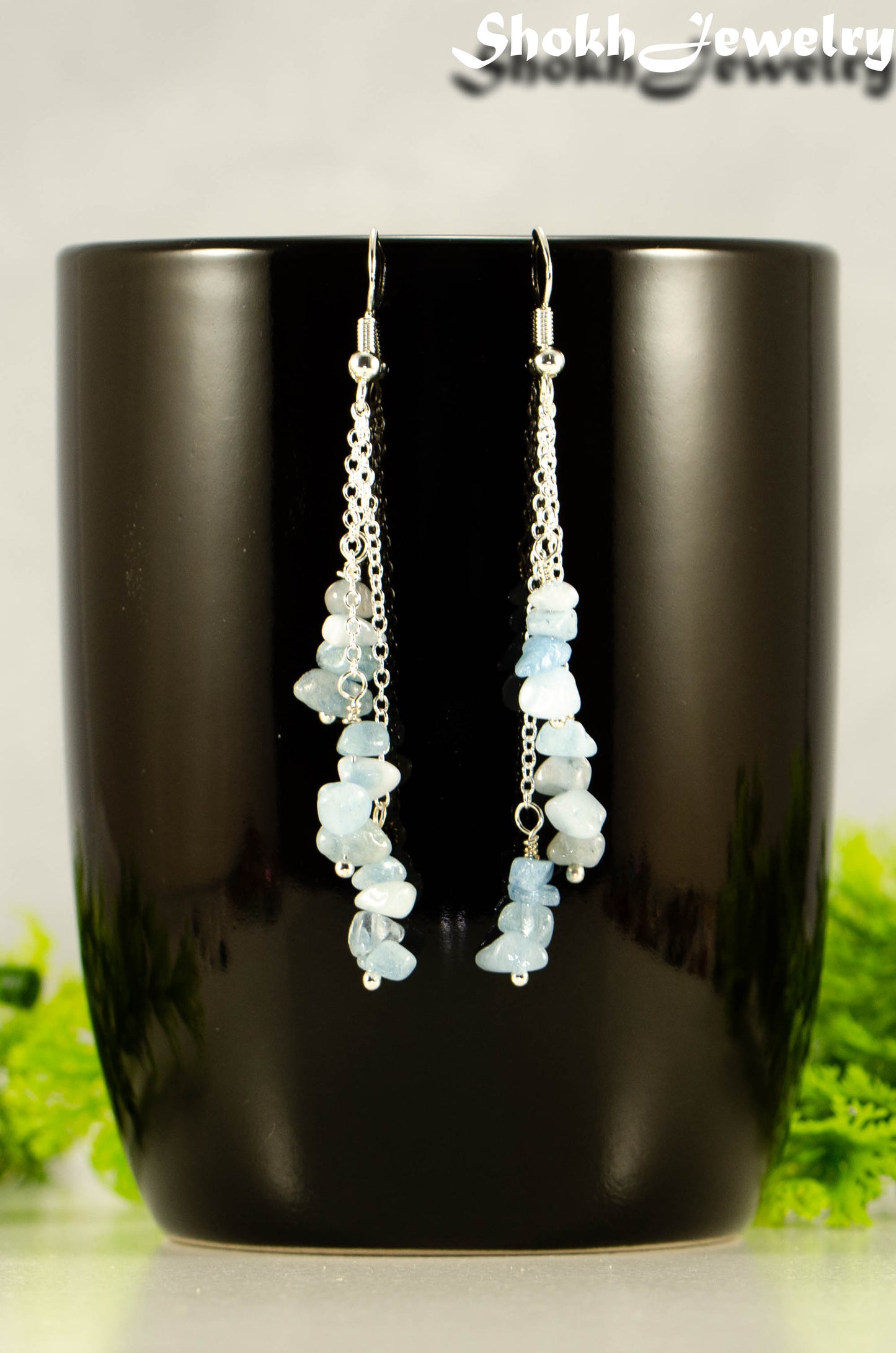 Long Silver Plated Chain and Aquamarine Crystal Chip Earrings on a mug