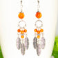 Close up of Statement Carnelian Crystal And Feather Earrings.