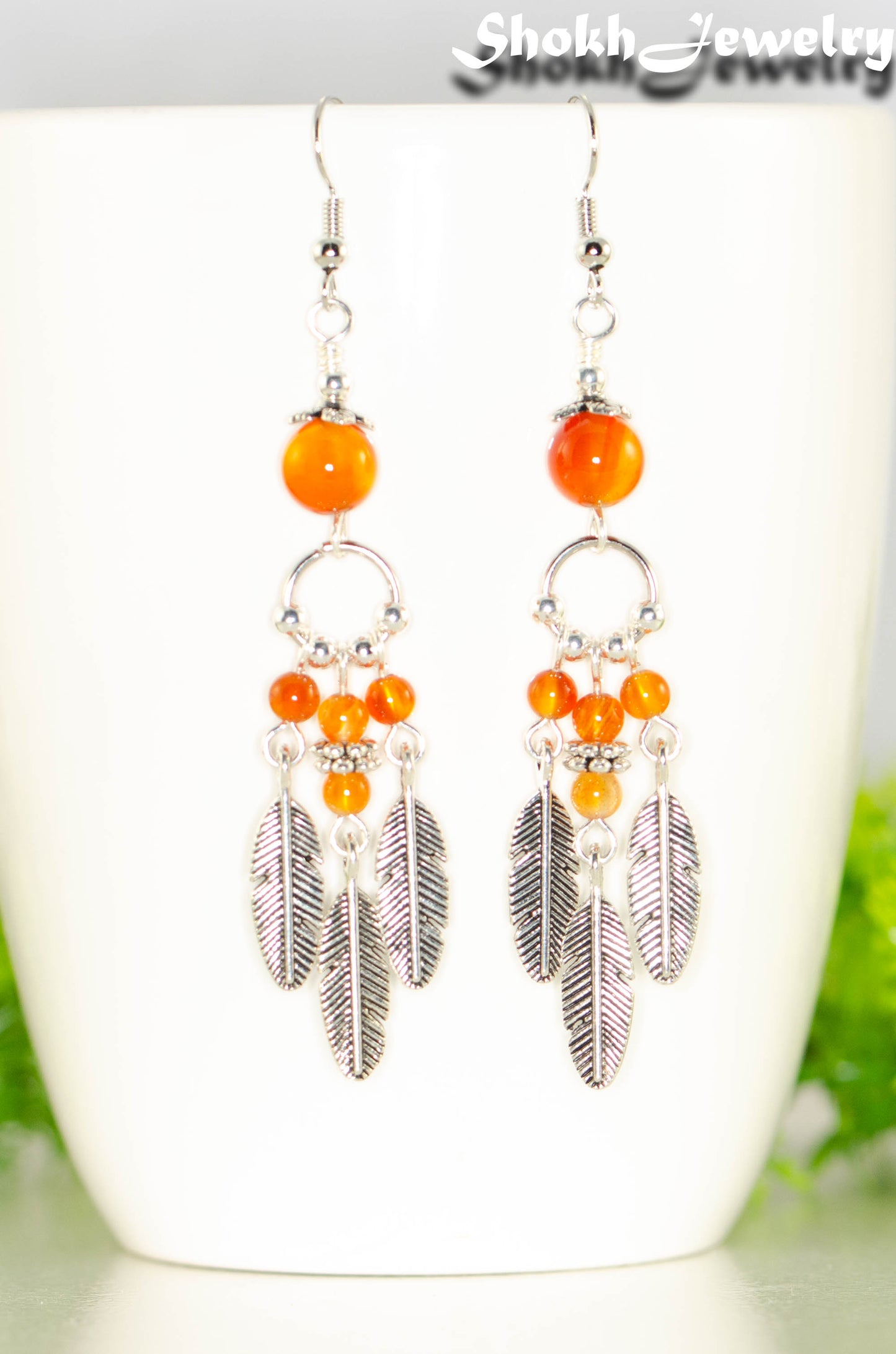 Close up of Statement Carnelian Crystal And Feather Earrings.