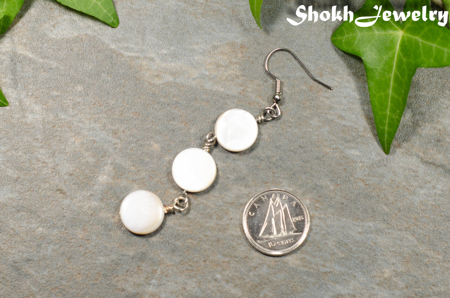 Long White Natural Seashell Earrings beside a dime.