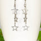 Stainless steel chain and star earrings on a mug
